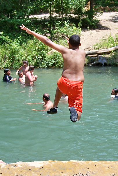 Kid jumping into creek at Chichasaw national recreational area