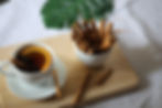 Cinnamon sticks in a mug next to a mug of cinnamon tea