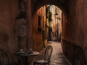 Narrow stone street in Palma old town at dusk, warm amber light on limestone walls`