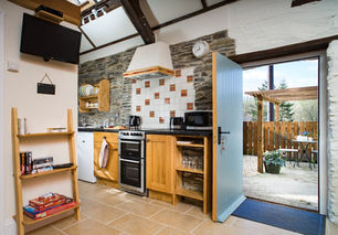 Fully equipped kitchen with rustic stone walls in a cosy West Wales holiday cottage