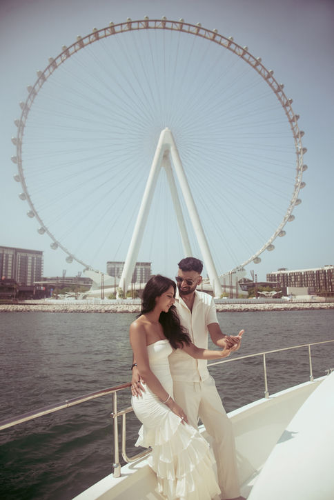 Couple on a yacht with Ain Dubai behind