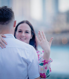 Bride-to-be showing her engagement ring while hugging her fiance