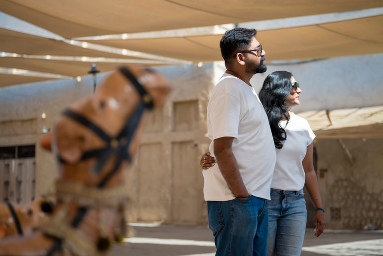Couple under shade sails in Old Dubai, camel figure in the foreground