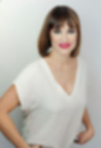 Mujer con cabello corto, blusa blanca y labios rojos.