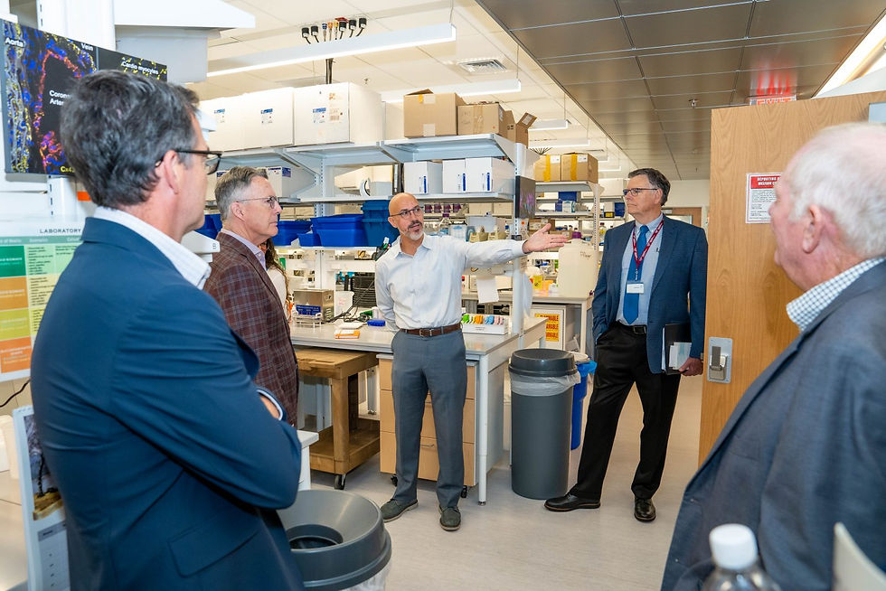 Stephen Poelzing (at center), professor at the Fralin Biomedical Research Institute and director of the Translational Biology, Medicine and Health Graduate Program, talks about cardiovascular research during the August meeting the Virginia Tech Board of Visitors. On hand (from left) were entrepreneur and Apex Systems co-founder Jeff Veatch, Virginia Tech President Tim Sands, Poelzing, institute Executive Director Michael Friedlander, and Donald Horsley, president of the Virginia Department of Agriculture and Consumer Services. Photo by Clayton Metz for Virginia Tech.