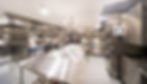 The large kitchen in a hotel with stainless steel counters and equipment