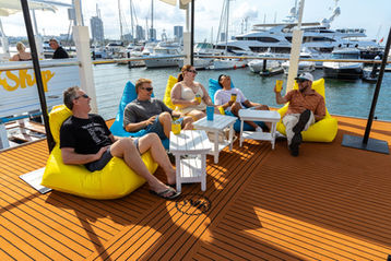 A group of people laughing sitting on bean bags on the top deck of Holy Ship