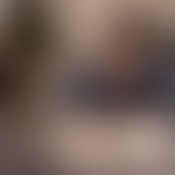 A small business owner writing in a notebook to updating his business plan.