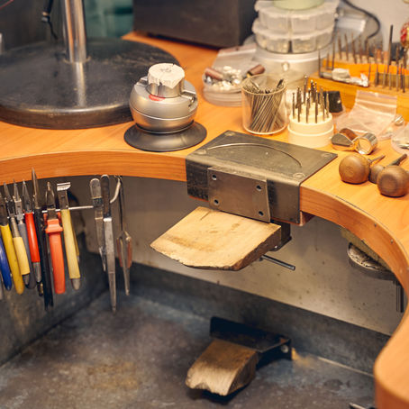 A clearly arranged workbench with tools and materials for jewelry making.