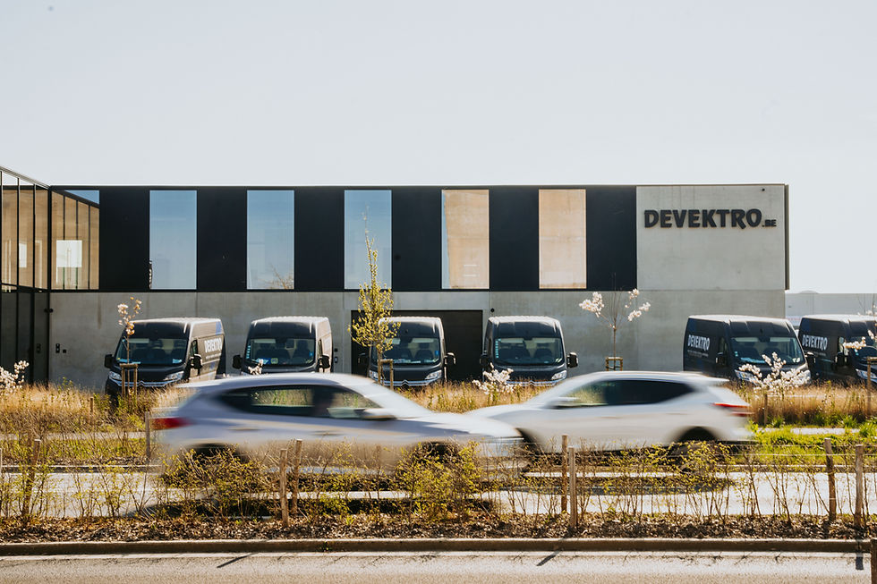 Bedrijfsgebouw van DEVEKTRO met bedrijfswagens geparkeerd voor de gevel.