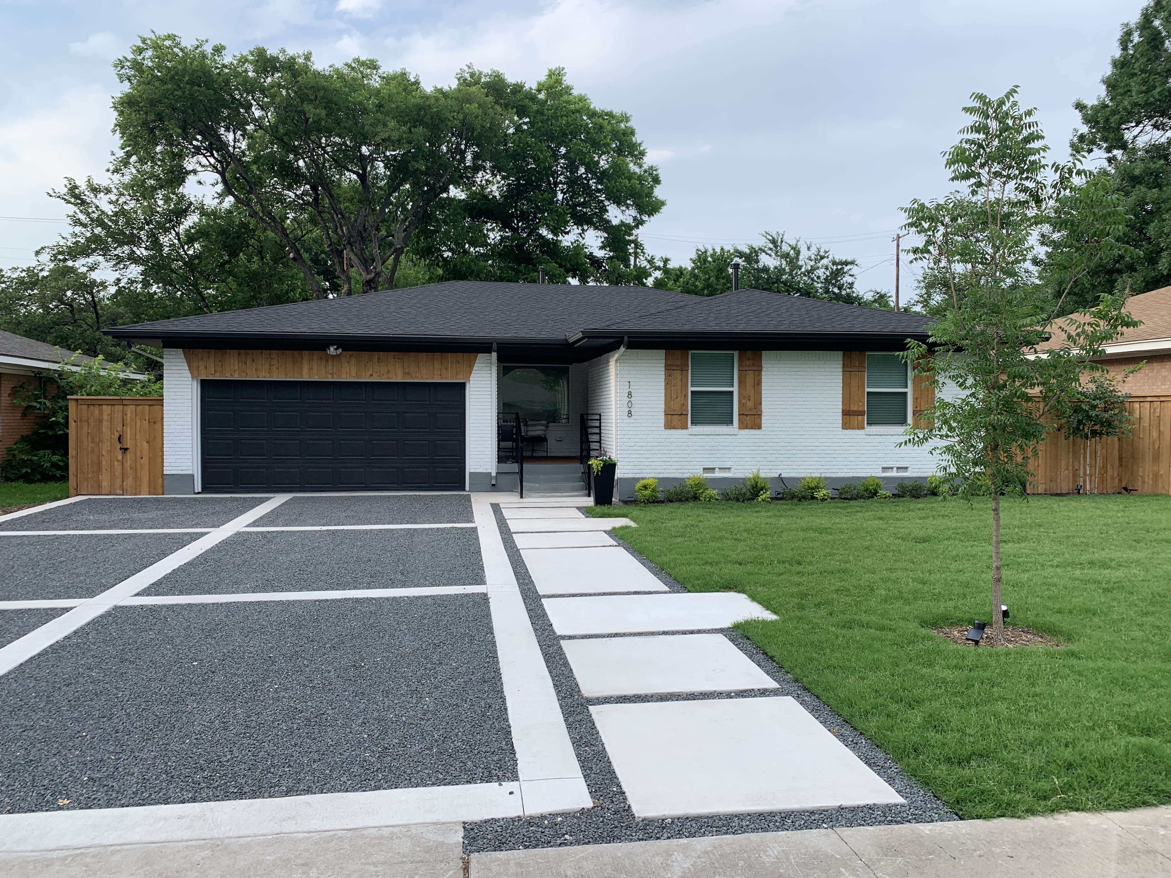 Concrete driveway and lawn at a modern home by Grayscape Landscape & Design, Dallas County, TX. Landscaper Near Me.