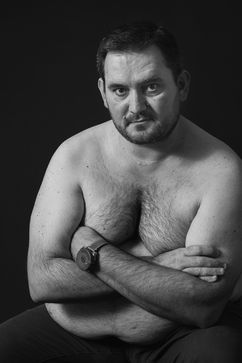 Bertrand Perret propose une séance de photothérapie en studio pour mieux accepter son corps et son obésité. Bras croisés