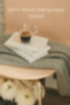 Glass coffee cup on books with a gray blanket and flowers on a table. Text reads: How to overcome stress by staying organized. Cozy mood.