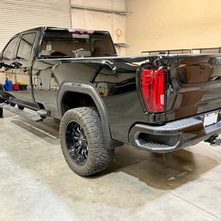 Rear side view of Black GMC Sierra truck at Robust Paint Protection & Auto Detailing Shop after a two-step paint correction In Napa