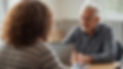 image of a female speech pathologist with brown curly hair (from behind) sitting across fr