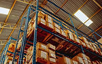 Corrugated shipping boxes on wood pallets in warehouse racking