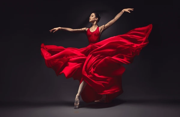 A ballerina wearing a red dress in a dance posture