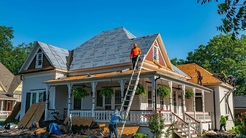 Roofing crew works on a home roof in Victoria, TX with underlayment, ladders, and materials during an exterior remodel.