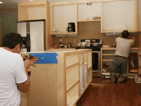 Kitchen remodeling in Victoria, Texas with two contractors installing wood cabinets and kitchen island