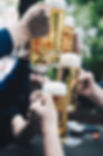 hands holding full beer glasses