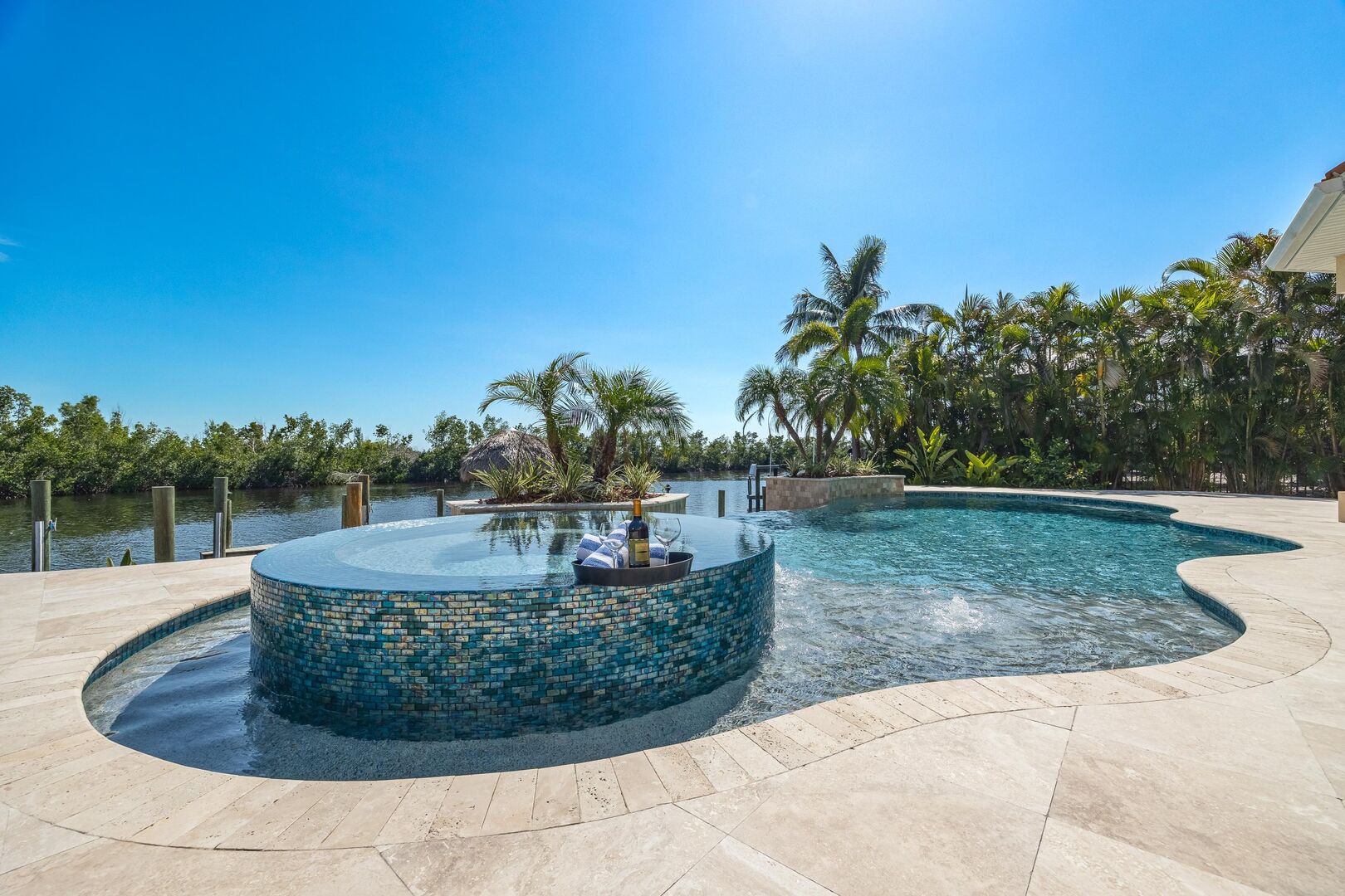 A canal-front pool and spa at a Roelens Vacations rental home