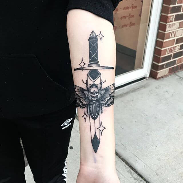 dagger and moth tattoo on left hand