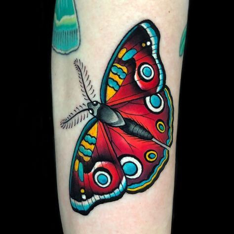 red minimalist moth tattoo on hand