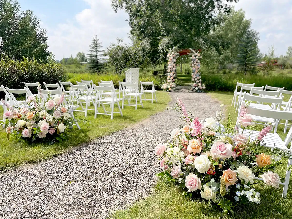Outdoor wedding ceremony space filled with floral decorations.