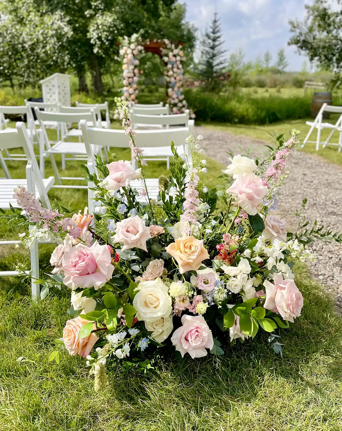 Outdoor wedding ceremony space filled with floral decorations.