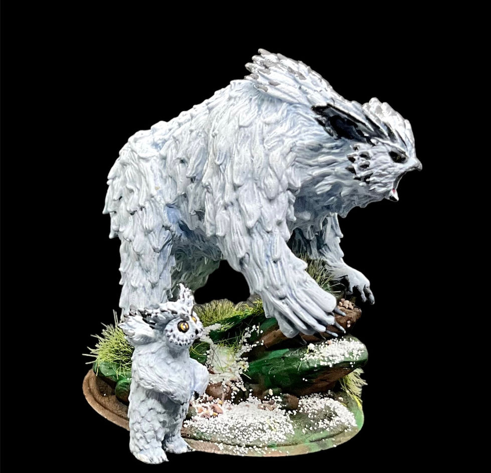 The side view of a painted miniature of a polar Owlbear with its cub.