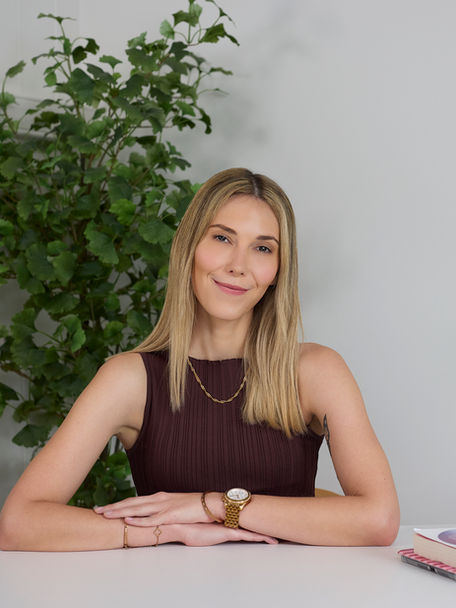 woman sitting at a desk with a book and green trees for a professional headshot by alise black studios