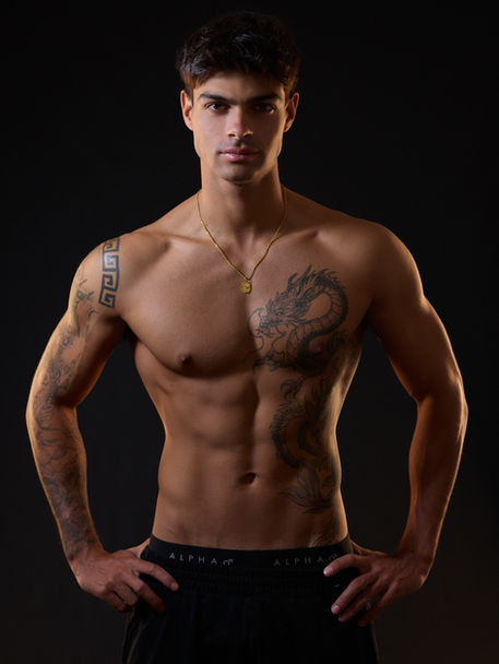 fitness photography of a man standing in a professional studio with athletic build photographed by Alise Black Studios 