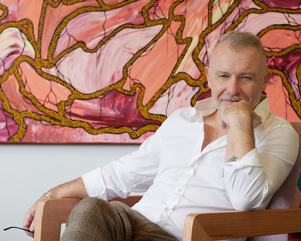 Personal Branding Photography by Alise Black Studios featuring a man seated in chair infront of orange patterned wall artwork
