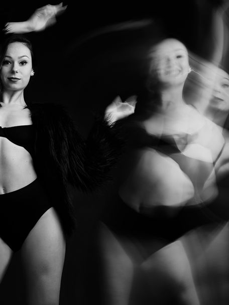 Cinemagraph Dance Photography of long haired woman standing in front of a black photo studio backdrop, wearing a black knicker and top. By Artist Photographer Alise Black Studios