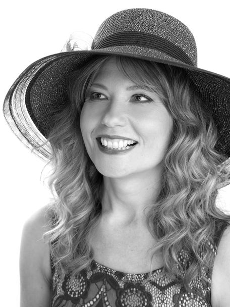 Black and white headshot photography of a blonde woman wearing a hat, smiling, standing in front of a white photo studio backdrop, by Headshot Photogrpaher Alise Black Studios, Brisbane, Sydney and Melbourne