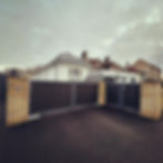 Eye-level view of a modern driveway gate with stone pillars