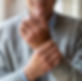 Elderly man holding wrist