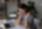 Woman holding nose at desk