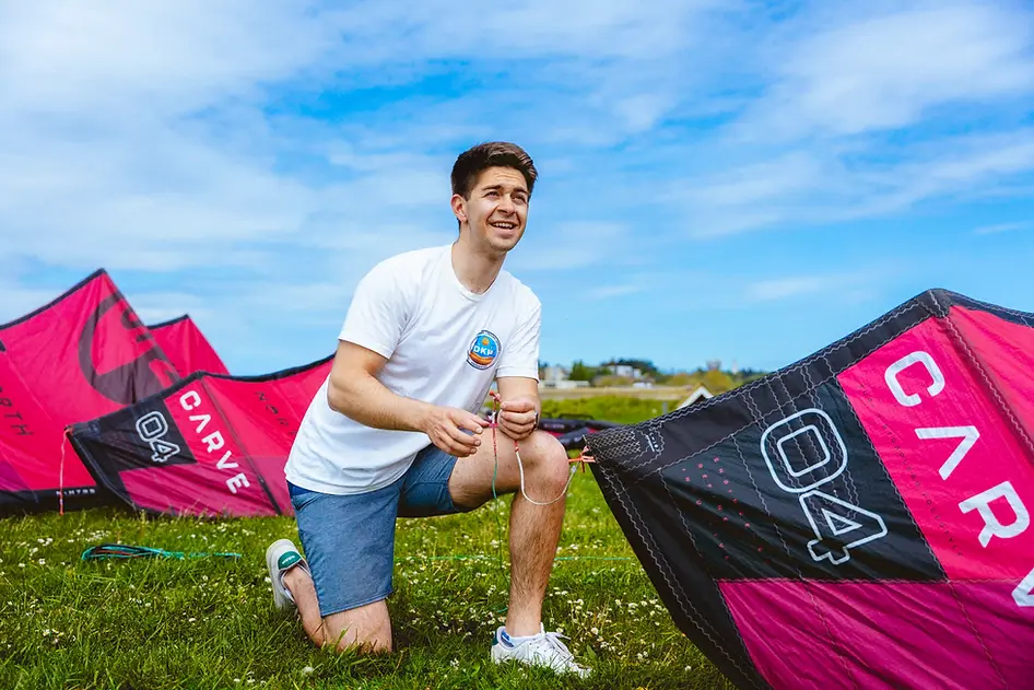 DKP Instructor setting up pink North kiteboarding kite on grass during intro Kite Ground l