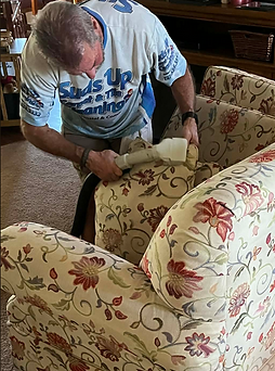 Suds Up Carpet Cleaning technician performing professional upholstery cleaning on a sofa in an Oldsmar Florida home.