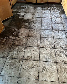 Flood-damaged tile and grout in Pasco County Florida home before restoration cleaning after hurricane flooding and construction debris.