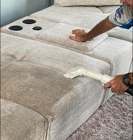 Professional upholstery cleaning removing embedded dirt from a fabric sofa