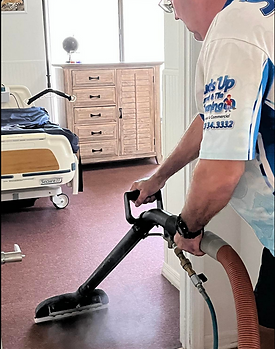 Suds Up Carpet Cleaning technician performing professional carpet cleaning at an assisted living facility in New Port Richey, Florida, removing dirt and restoring high traffic hallway carpet.