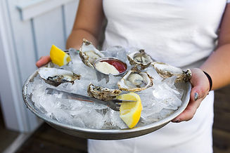 Oysters on the half shell over ice, served with cocktail sauce and horseradish