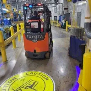 Forklift moving towards a SafetyCast Projected Pedestrian Warning Sign