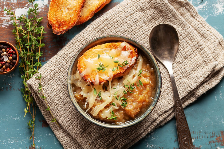 Classic French onion soup baked with cheese croutons sprinkled with fresh thyme Top view.j
