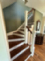 Wooden staircase with white risers and teal walls