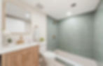 Modern bathroom remodel with wood vanity, green tiled shower