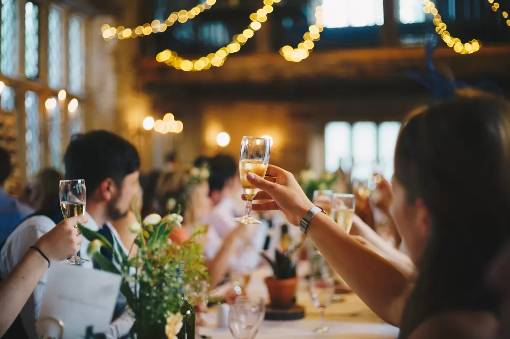 Festlokal Upplands Väsby åtnjuts av sällskap hållandes i champagneglas med champagne i