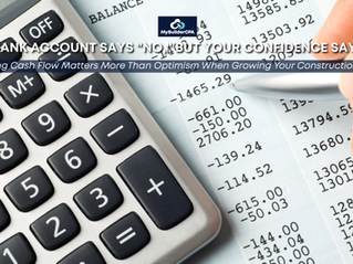 Construction business owner reviewing financial reports and cash flow statements in an office while evaluating whether the company has enough financial capacity to take on a new construction project.